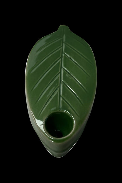 Green glass pipe shaped like a cannabis leaf.