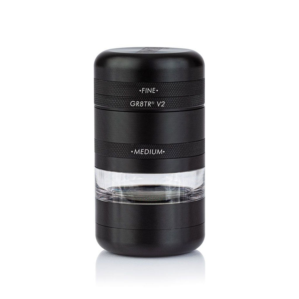 Centered front view of the matte black RYOT GR8TR Jar Body Grinder showing stacked cylindrical sections with textured bands and a clear middle chamber.