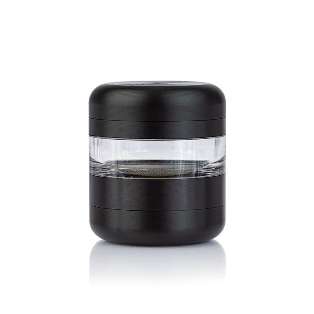 Centered front view of the black RYOT GR8TR Jar Body Grinder with a clear middle chamber on a white reflective surface