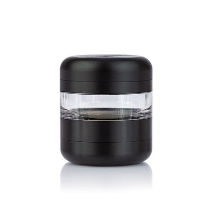 Centered front view of the black RYOT GR8TR Jar Body Grinder with a clear middle chamber on a white reflective surface