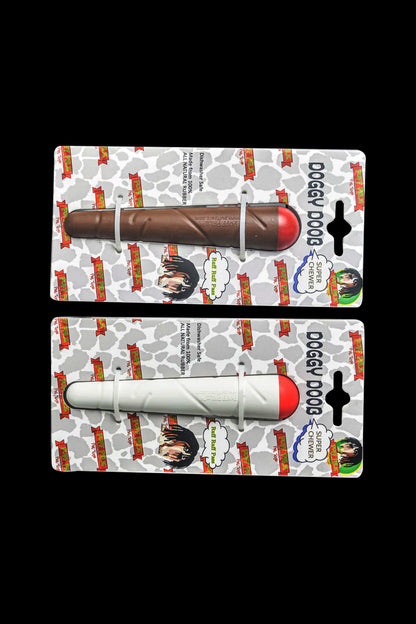 Top-down view of two packaged Puff Palz Doggie Doob Dog Toy items, one brown and one white with red tips, on patterned backing.