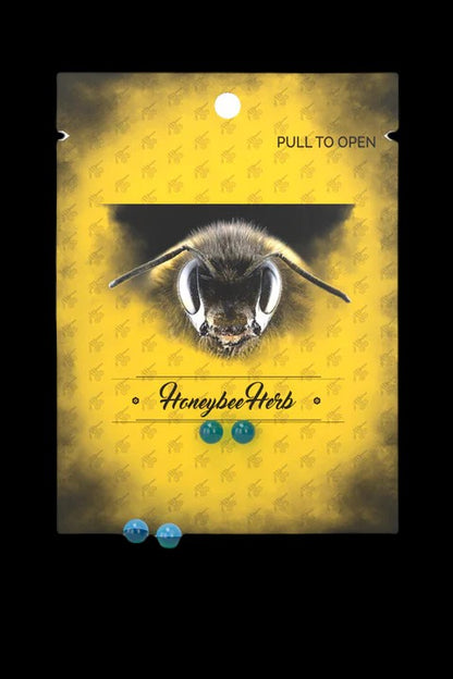 Close-up of a bee’s face on a yellow patterned packaging labeled “HoneybeeHerb” with pull-tab openings.
