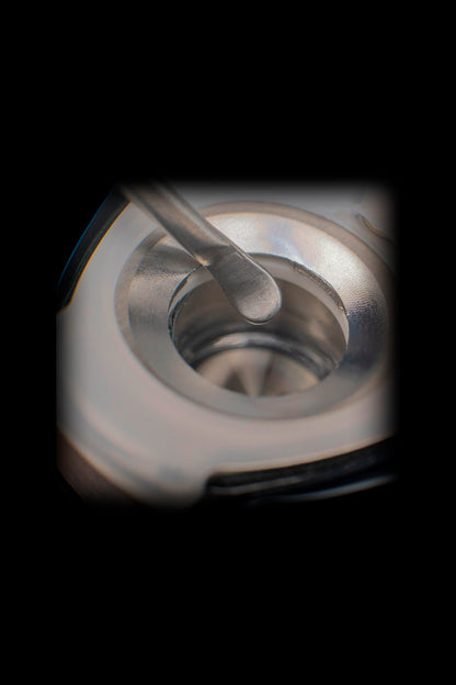 Close-up of a dab rig with a tool poised over a quartz banger.