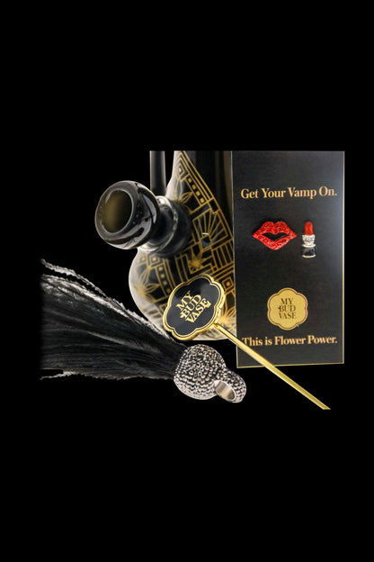 A product shot of “My Bud Vase” cannabis accessories featuring a glass water pipe with a decorative, textured base, displayed against a dark background with marketing text reading “Get Your Vamp On” and “This is Flower Power.”