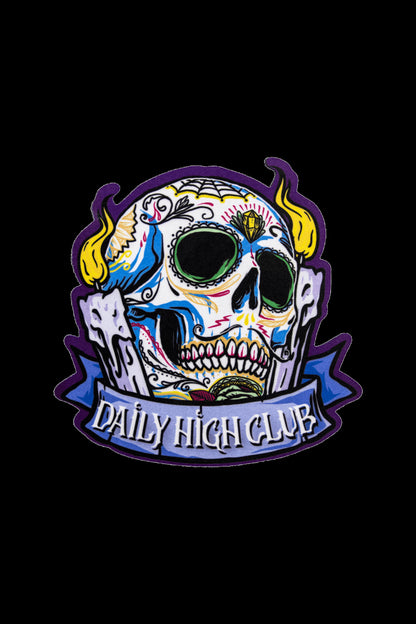 A vibrant, embroidered patch featuring a colorful sugar skull design with the text "DAILY HIGH CLUB" below it.