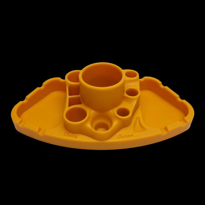 Front-facing view of a black-background orange Blazy Susan Deluxe Dab Station with multiple round wells and a central cup.