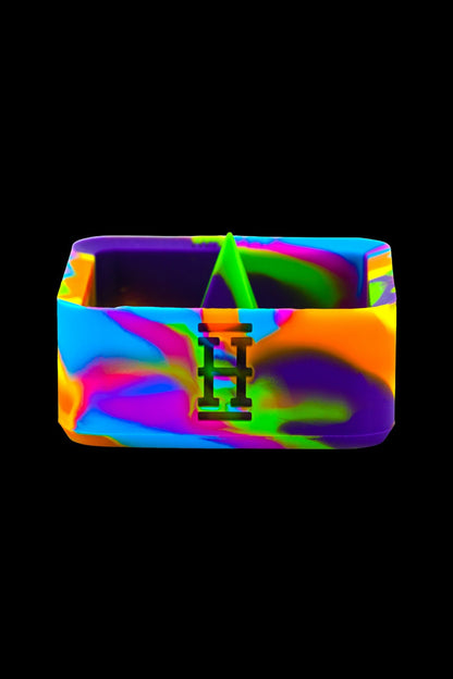 Colorful silicone cannabis concentrate container with a black "H" logo.