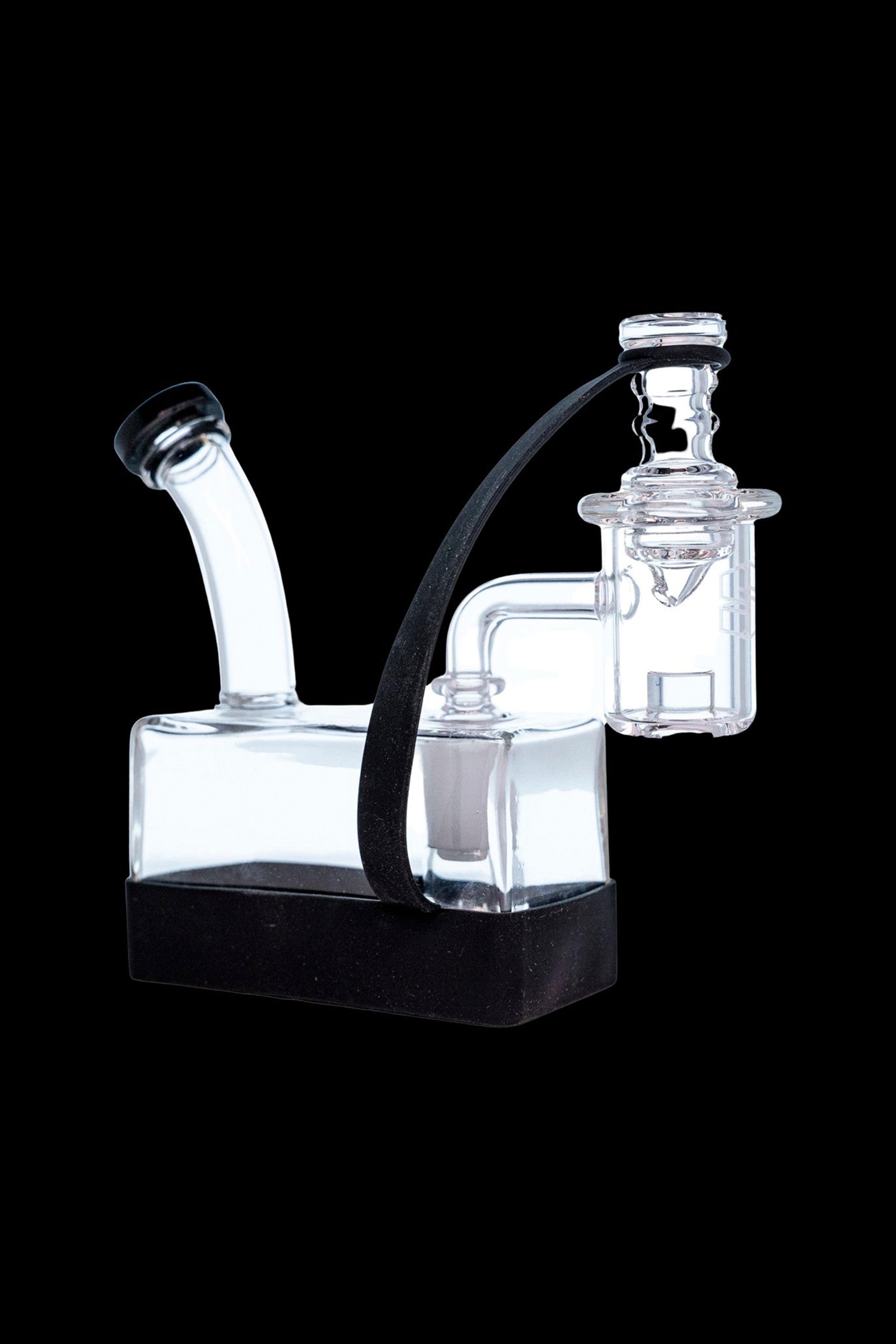 Clear glass rig with a black base and silicone tubing, used for vaporizing concentrates.