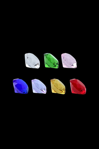 Row of faceted, diamond-shaped glass caps on a black background, featuring a central green piece in the top row — The Stash Shack Diamond Cut Glass Carb Cap