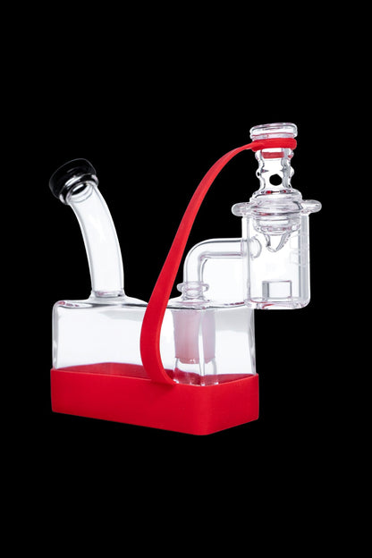 Clear glass dab rig with red accents and silicone base.