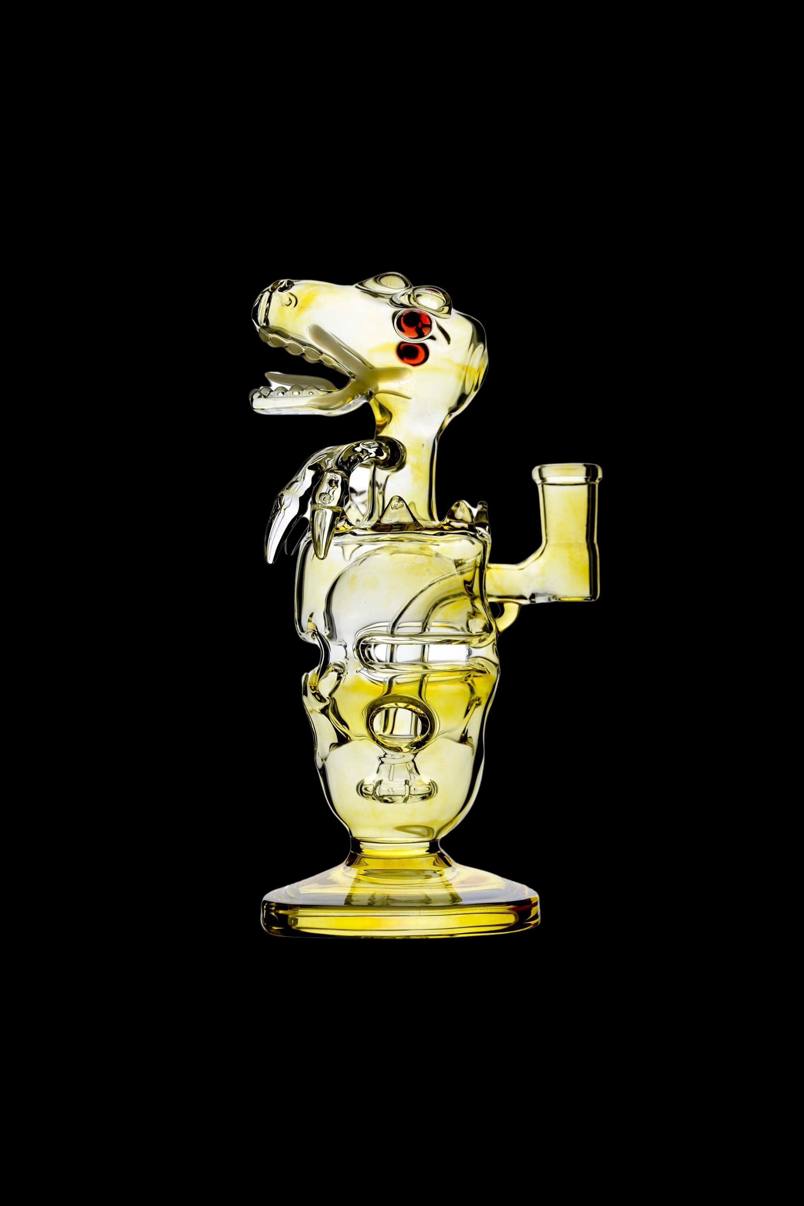 Side profile of a yellow glass Calibear Fab Dino Rig with an open-mouthed dino head and red eye against a black background