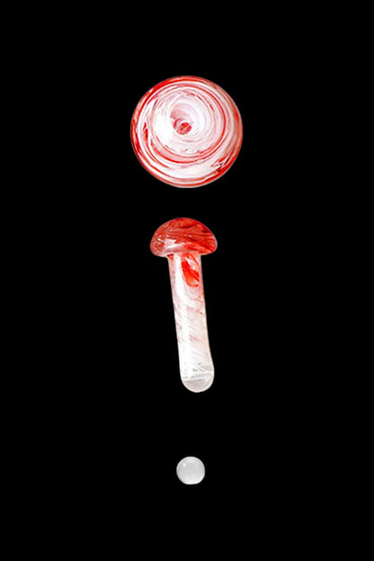 Red and white swirled glass cannabis oil burner pipe and carb cap against a black background.