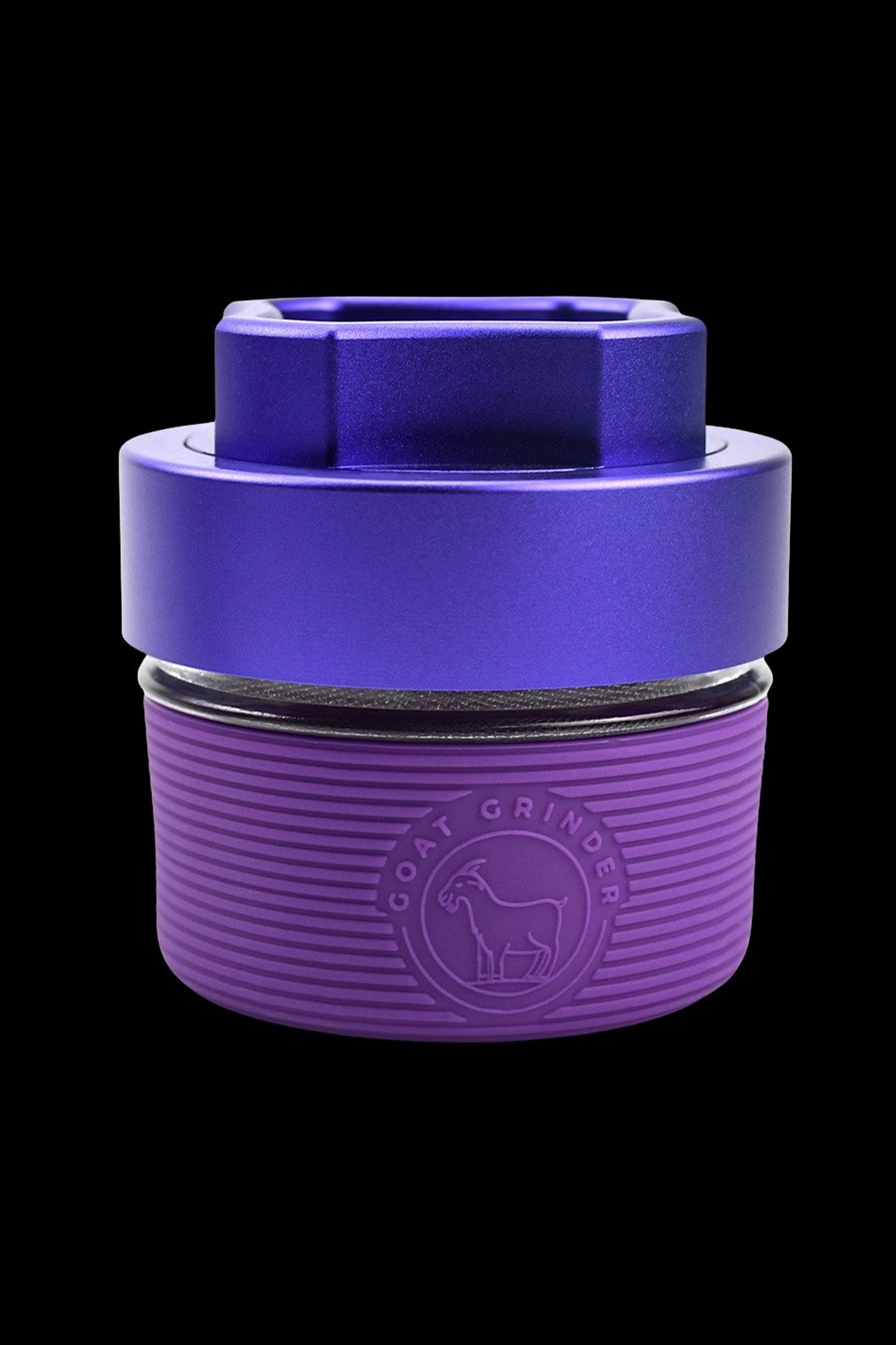 Purple cannabis grinder with a goat logo, displaying visible ground herbs inside.