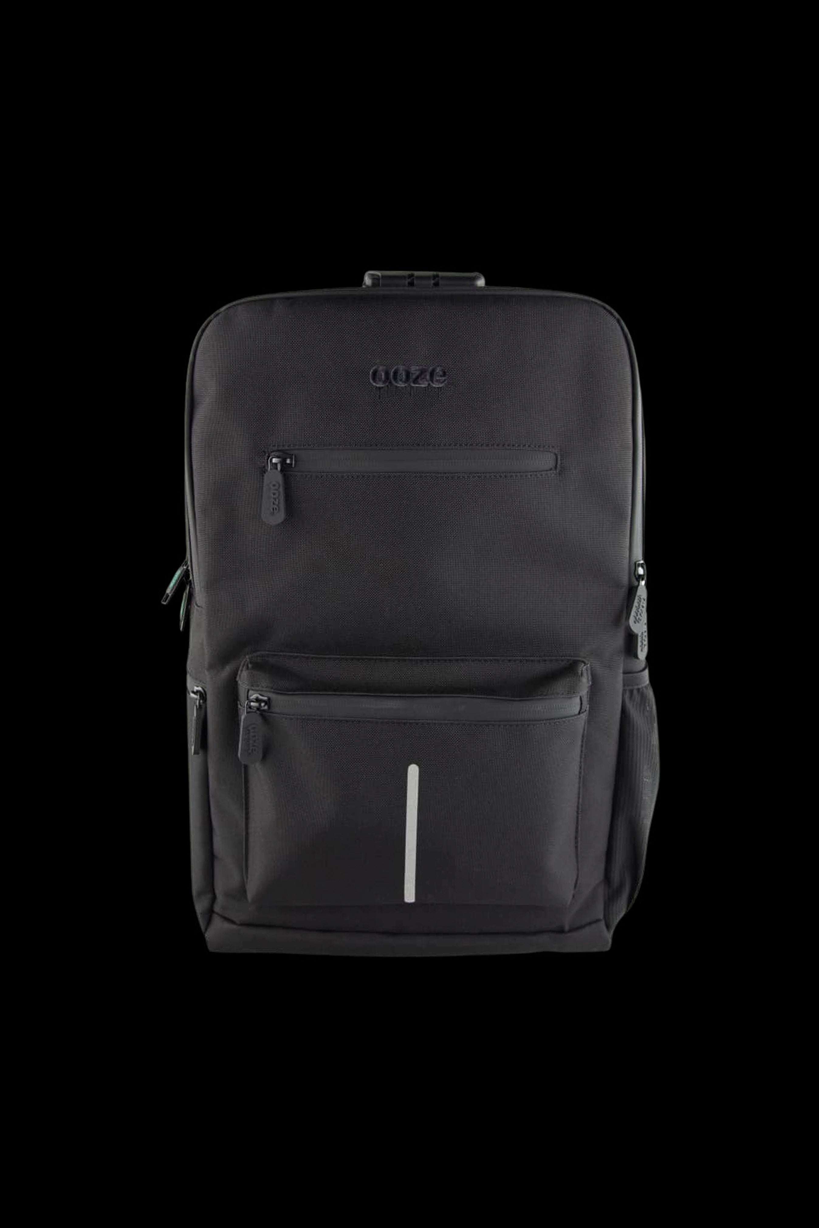 Front-facing close-up of the black Ooze Traveler Smell Proof Backpack showing textured fabric, zippers, embossed logo, and vertical reflective strip.