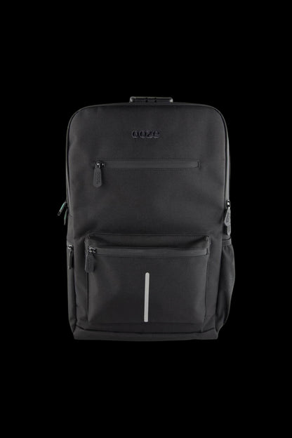 Front-facing close-up of the black Ooze Traveler Smell Proof Backpack showing textured fabric, zippers, embossed logo, and vertical reflective strip.