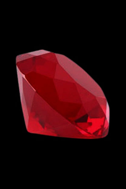 Close-up angled view of the red The Stash Shack Diamond Cut Glass Carb Cap against a black background, highlighting its faceted gem-like surfaces.