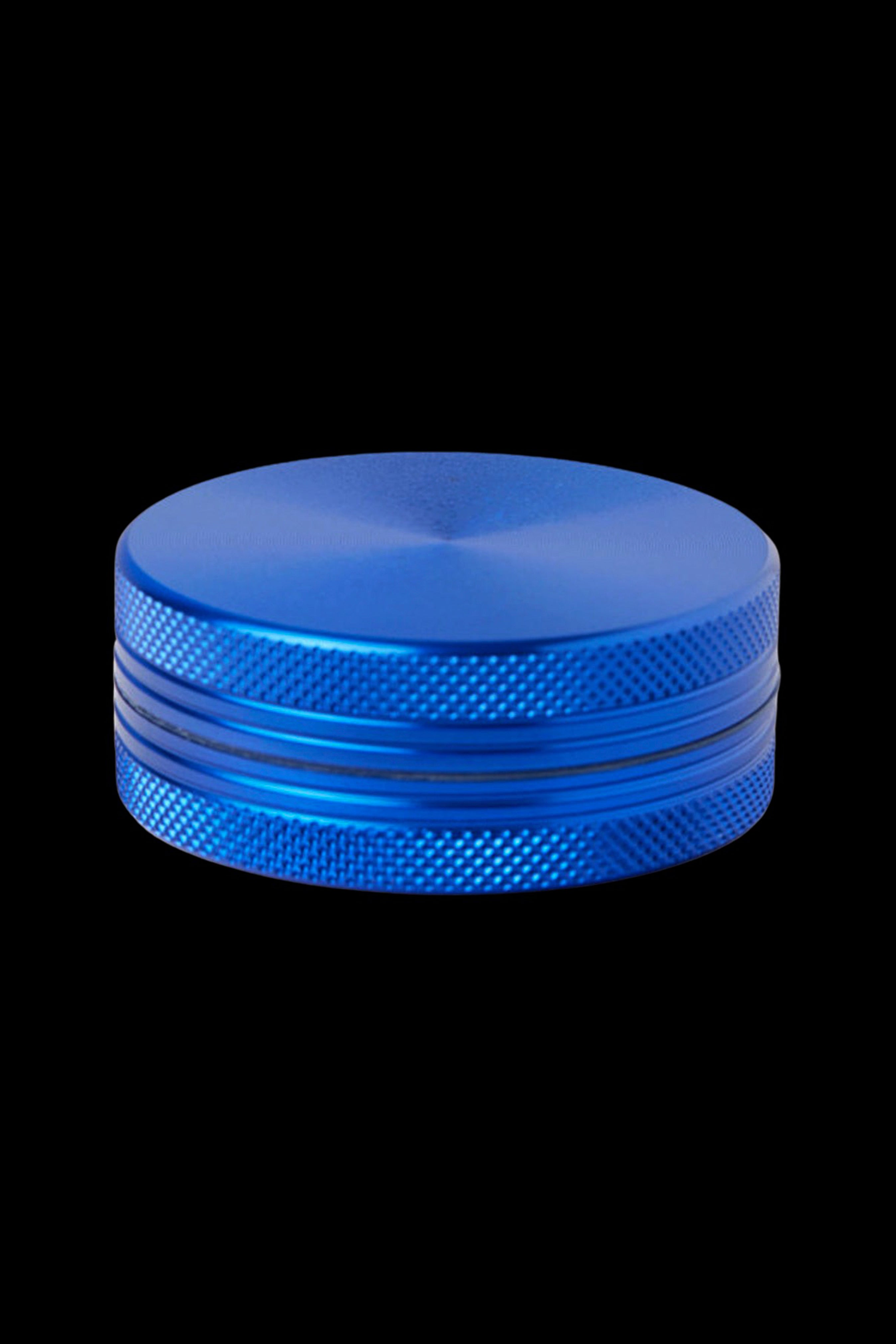 Blue metal cannabis grinder isolated on a black background.