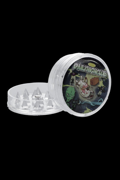 Clear grinder with a colorful, cartoonish lid depicting aliens and a pig.