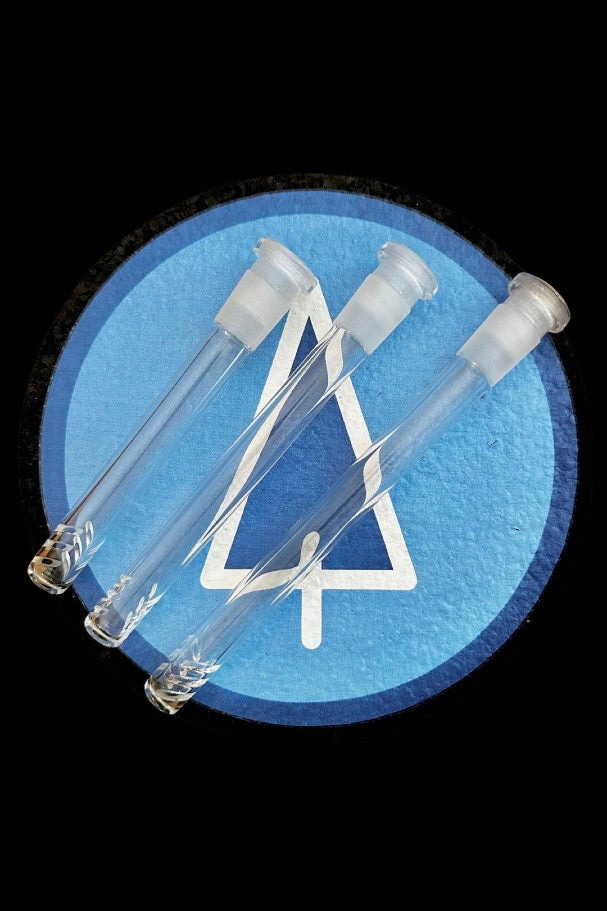 Glass downstems for water pipes displayed against a blue, textured circle with a cannabis leaf outline.