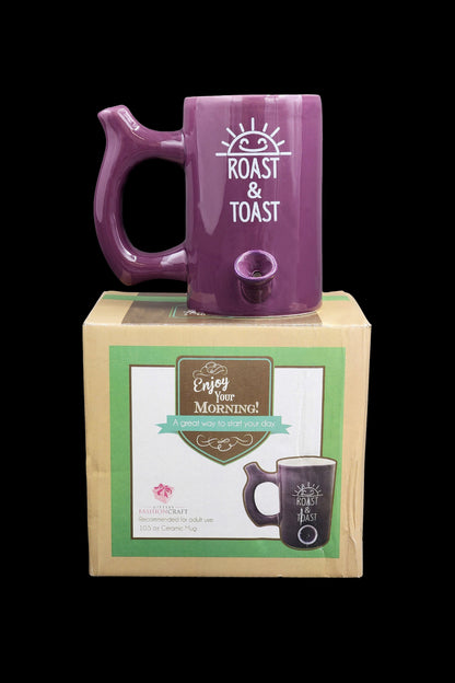 Purple ceramic mug with “Roast & Toast” lettering in a retail box, suggesting cannabis consumption accessory.