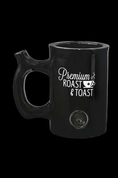Black ceramic mug with white text reading "Premium Roast & Toast" and a cannabis leaf illustration.