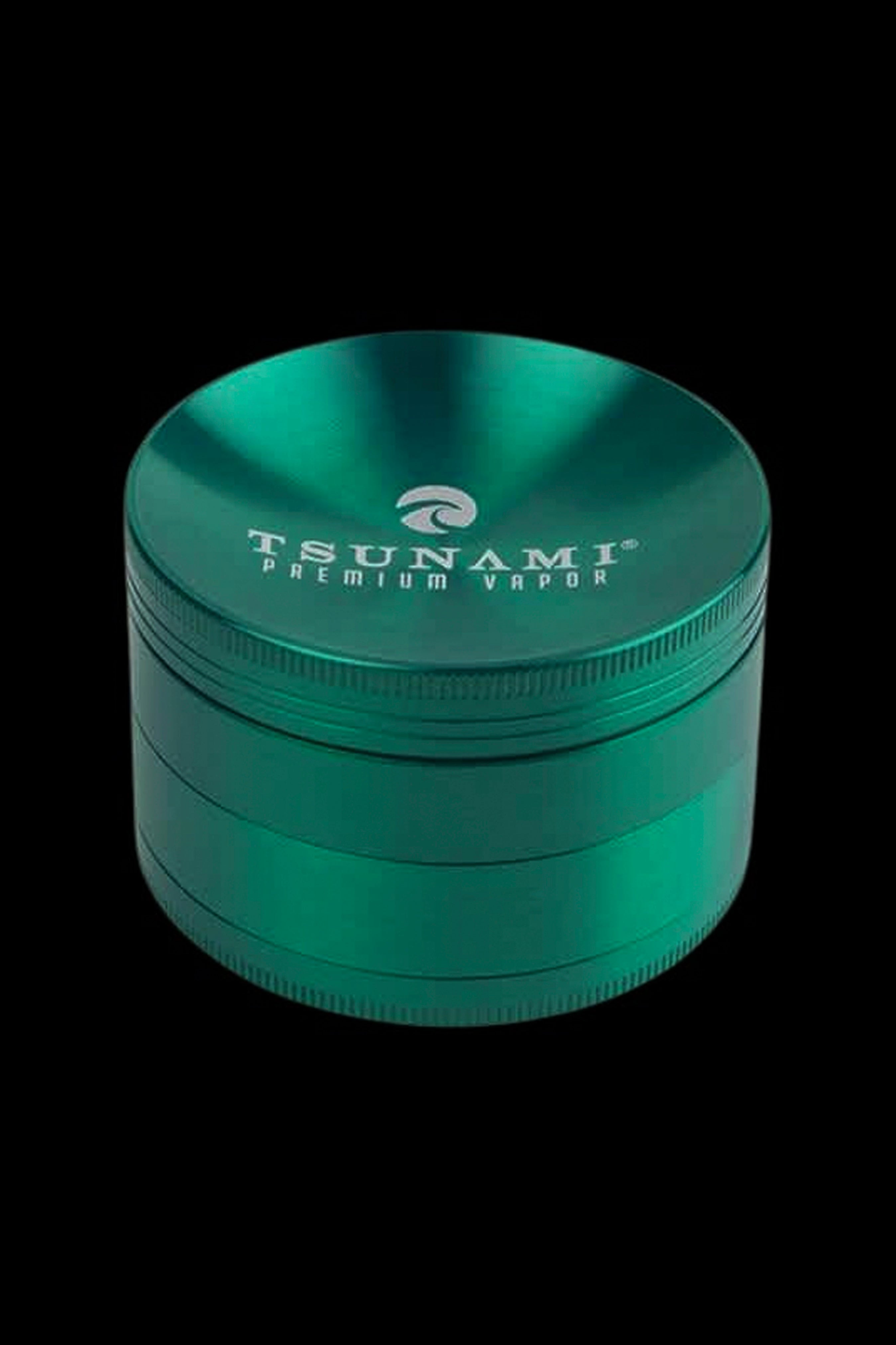 Emerald green four-piece cannabis grinder with “Tsunami Premium Vapor” branding.