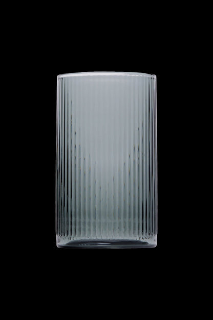 Ribbed glass smoking pipe against a black background.