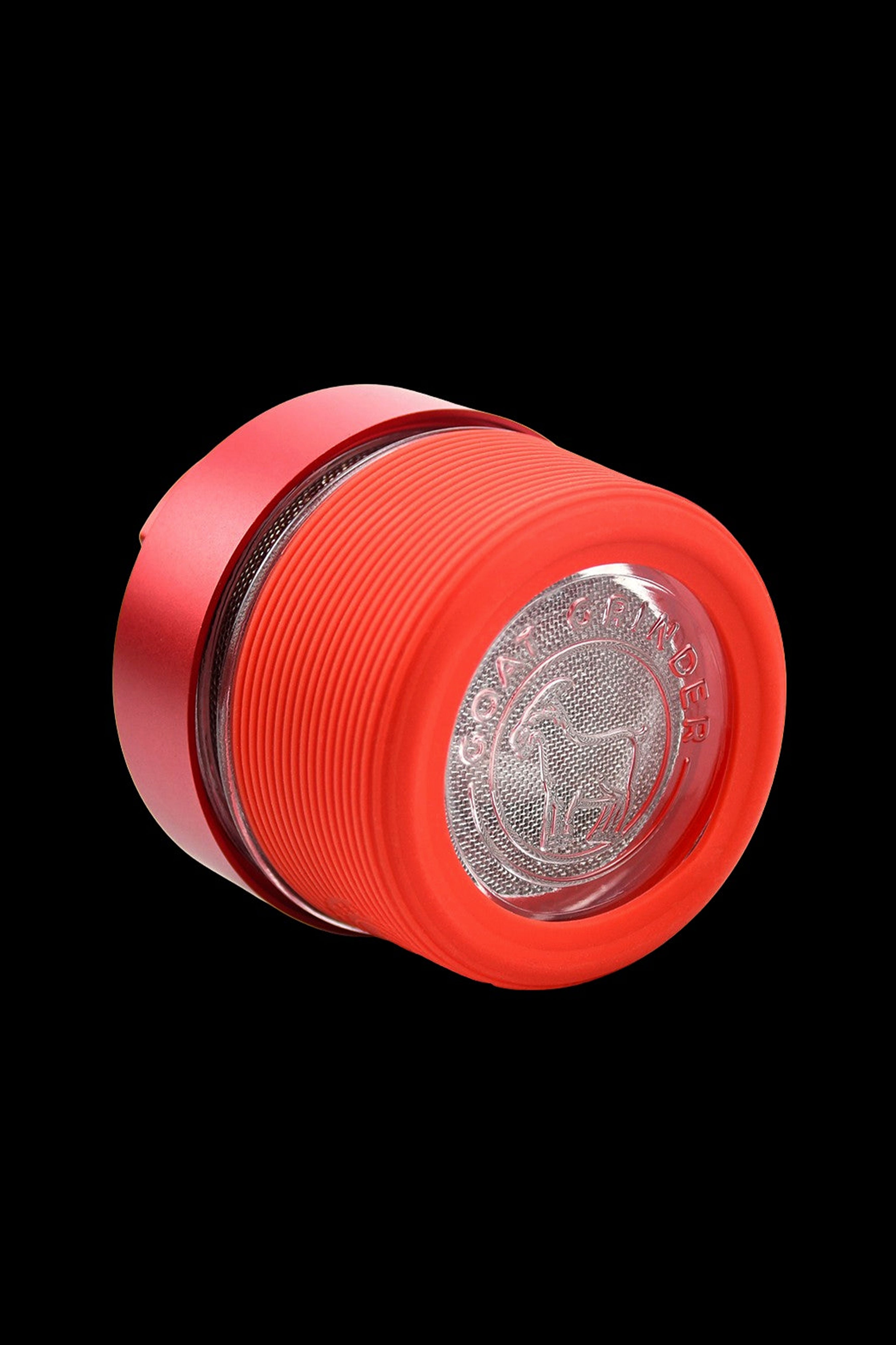 Red cannabis grinder with a patterned, transparent interior.