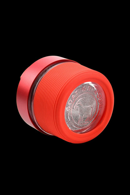 Red cannabis grinder with a patterned, transparent interior.