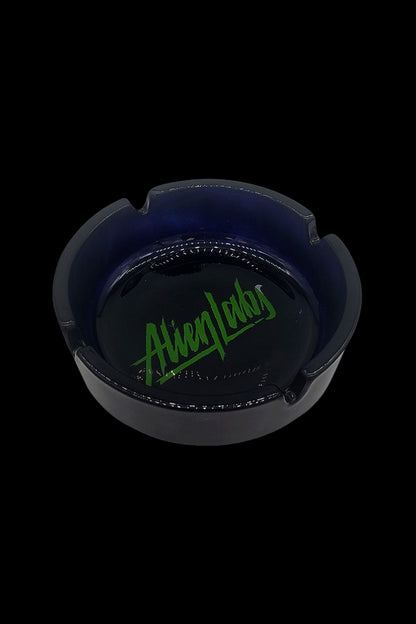 Black glass ashtray with green “Alien Labs” logo.