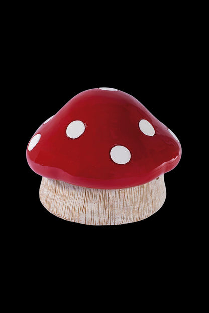 Red and white spotted mushroom-shaped cannabis storage container.
