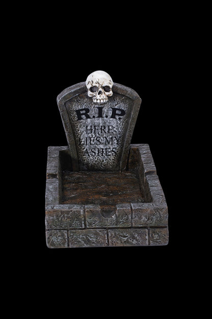 A spooky Halloween-themed ashtray shaped like a tombstone with “R.I.P. HERE LIES MY ASHES” inscribed on it.