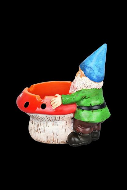 Ceramic garden gnome ashtray with a red mushroom cap and textured base, isolated on black.