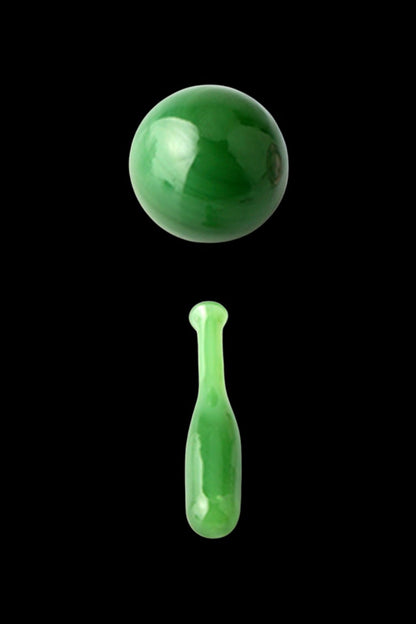 Green glass cannabis water pipe and sphere against a black background.