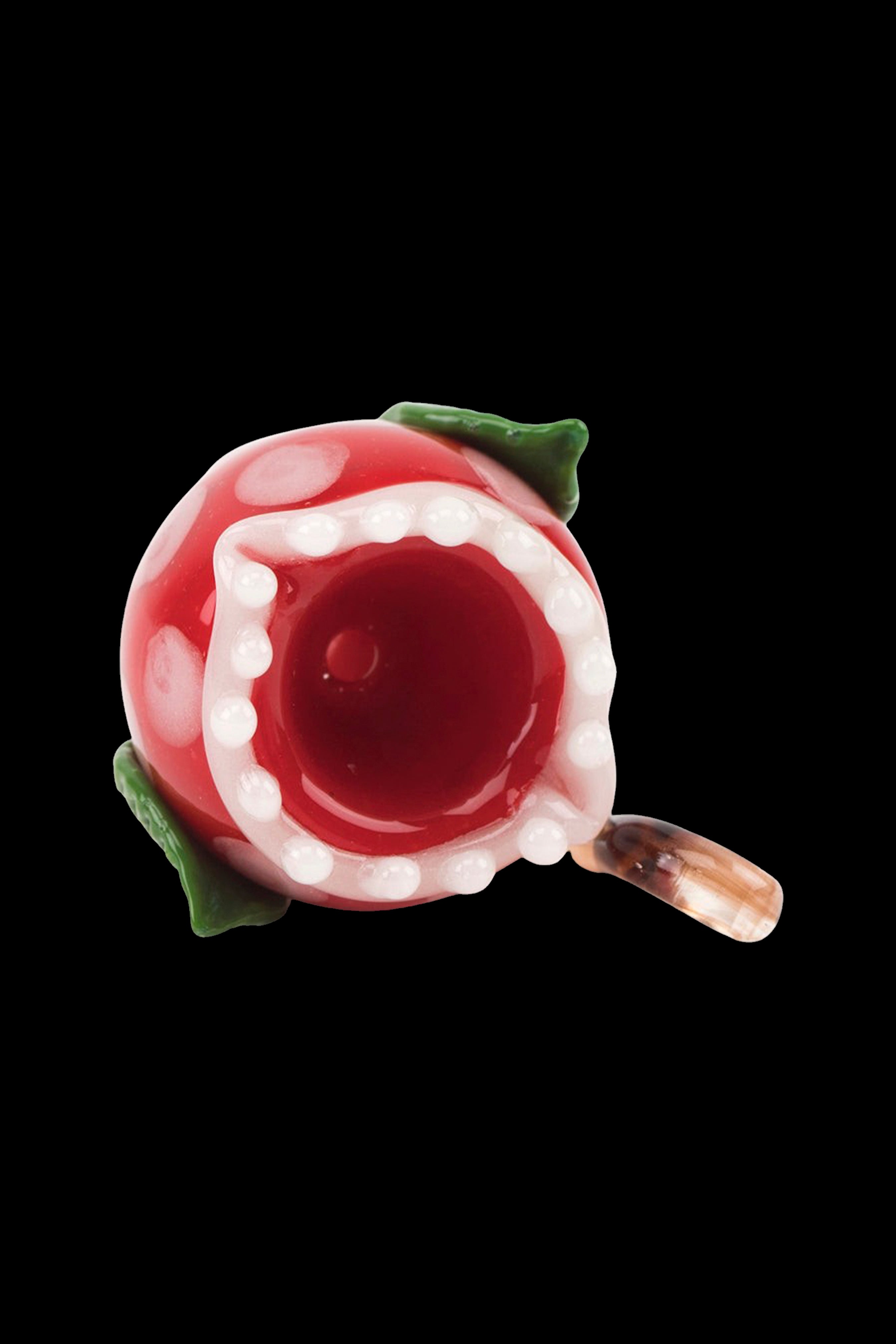 Red glass pipe shaped like a blooming flower with green leaf accents, isolated on a black background.