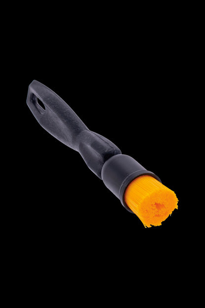 Black and orange detailing brush for cleaning cannabis accessories.