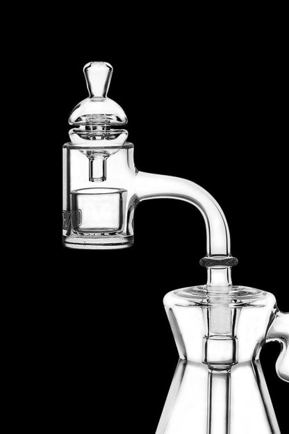 Clear glass dab rig with intricate bubbler design against a black background.