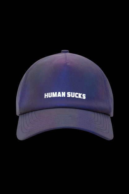 A vibrant blue and purple gradient baseball cap with “HUMAN SUCKS” embroidered in white across the front.