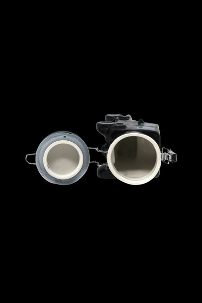 Overhead view of a transparent cannabis grinder with two chambers, isolated on a black background.
