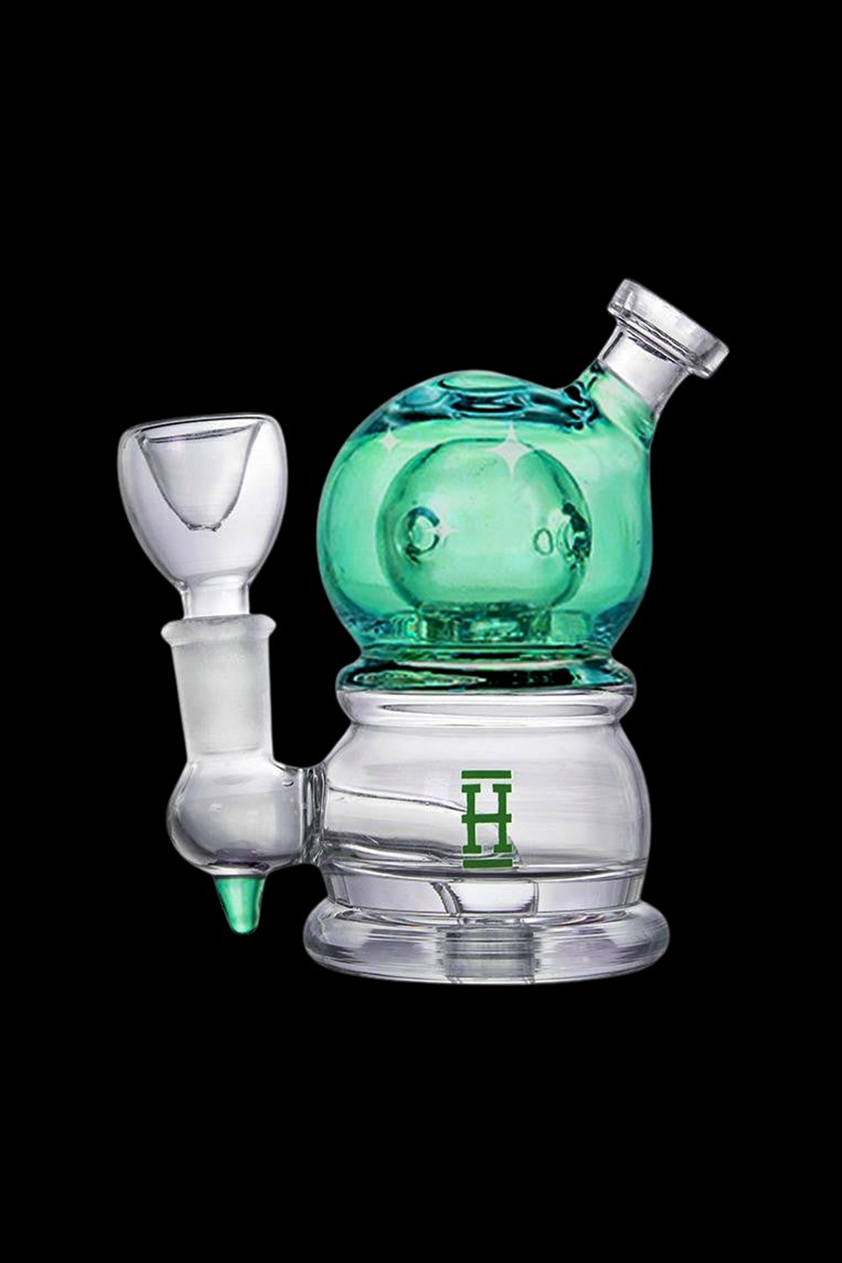 A turquoise glass rig with a clear mouthpiece and joint, featuring a green logo.