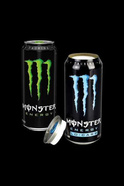 Two Monster Energy drinks, one closed and one open revealing a silver smoking bowl inside, on a black background.