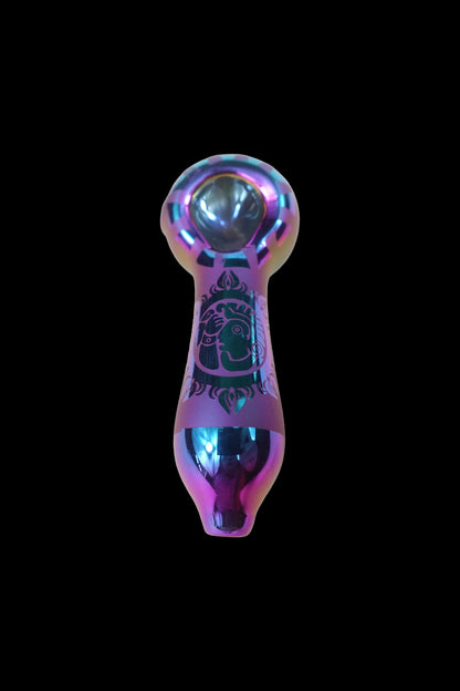 Iridescent glass pipe with etched designs, isolated on a black background.