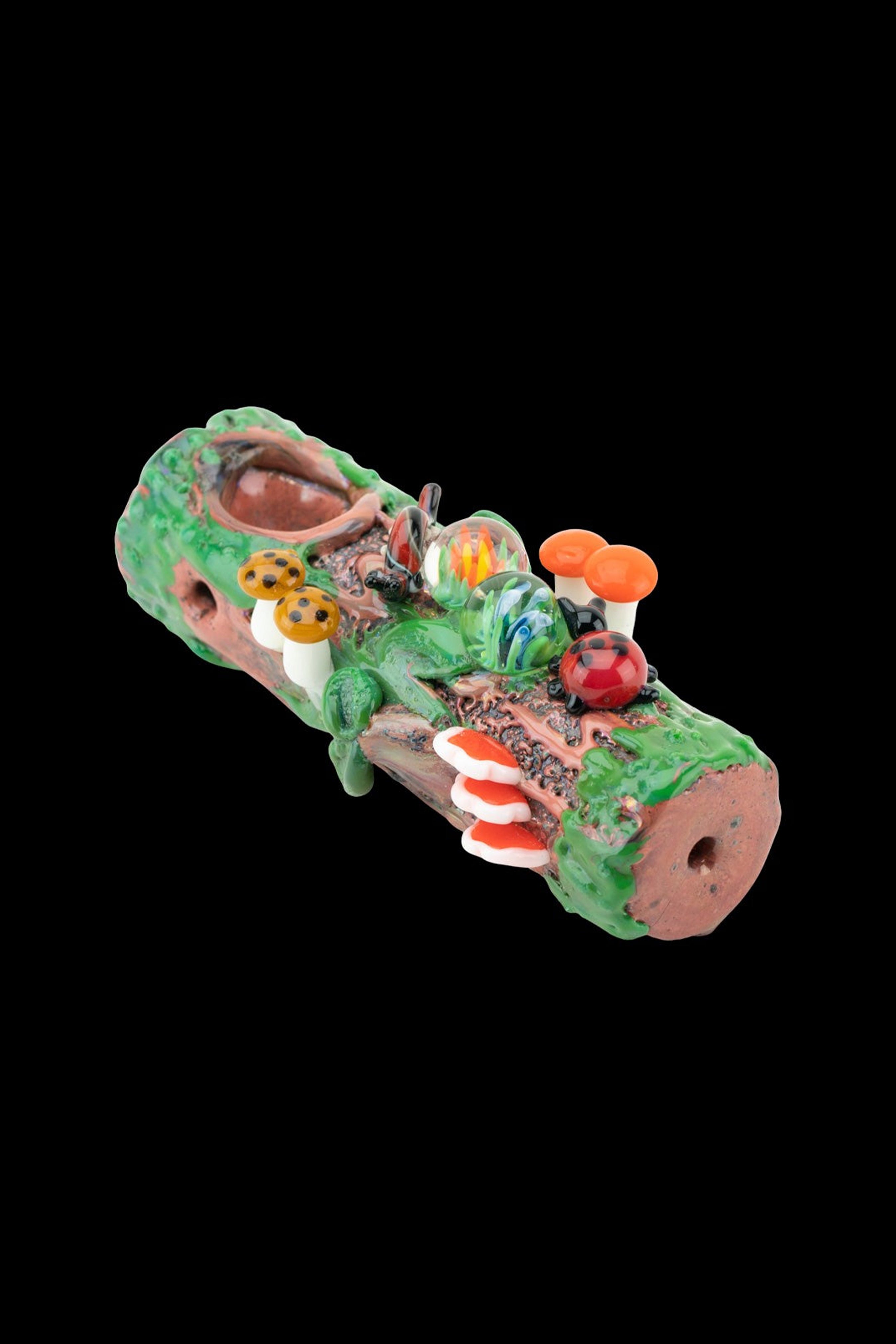 Hand-blown glass pipe sculpted to resemble a mossy log with colorful mushroom and ladybug details.
