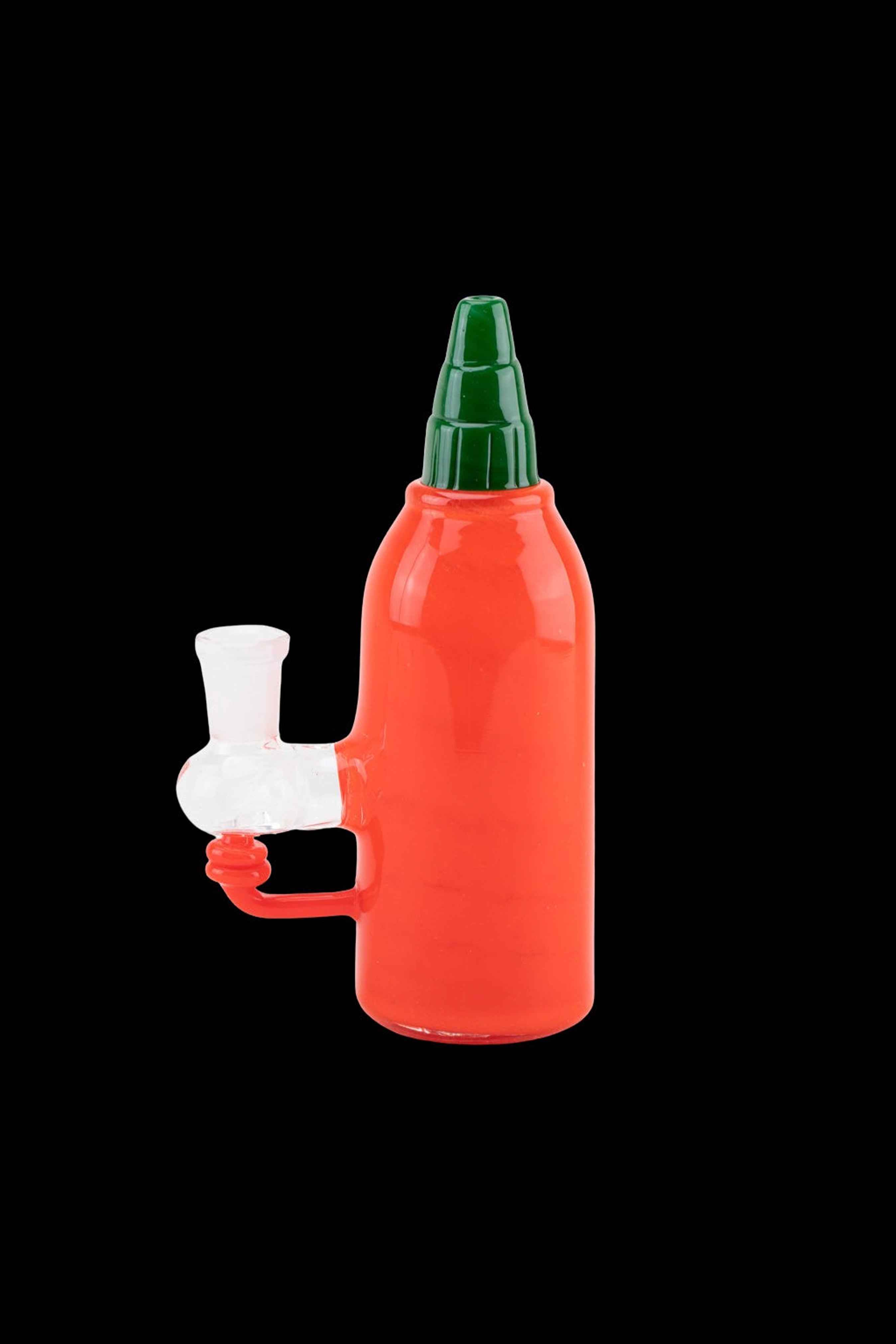 Red glass water pipe shaped like a hot sauce bottle with a white mouthpiece.