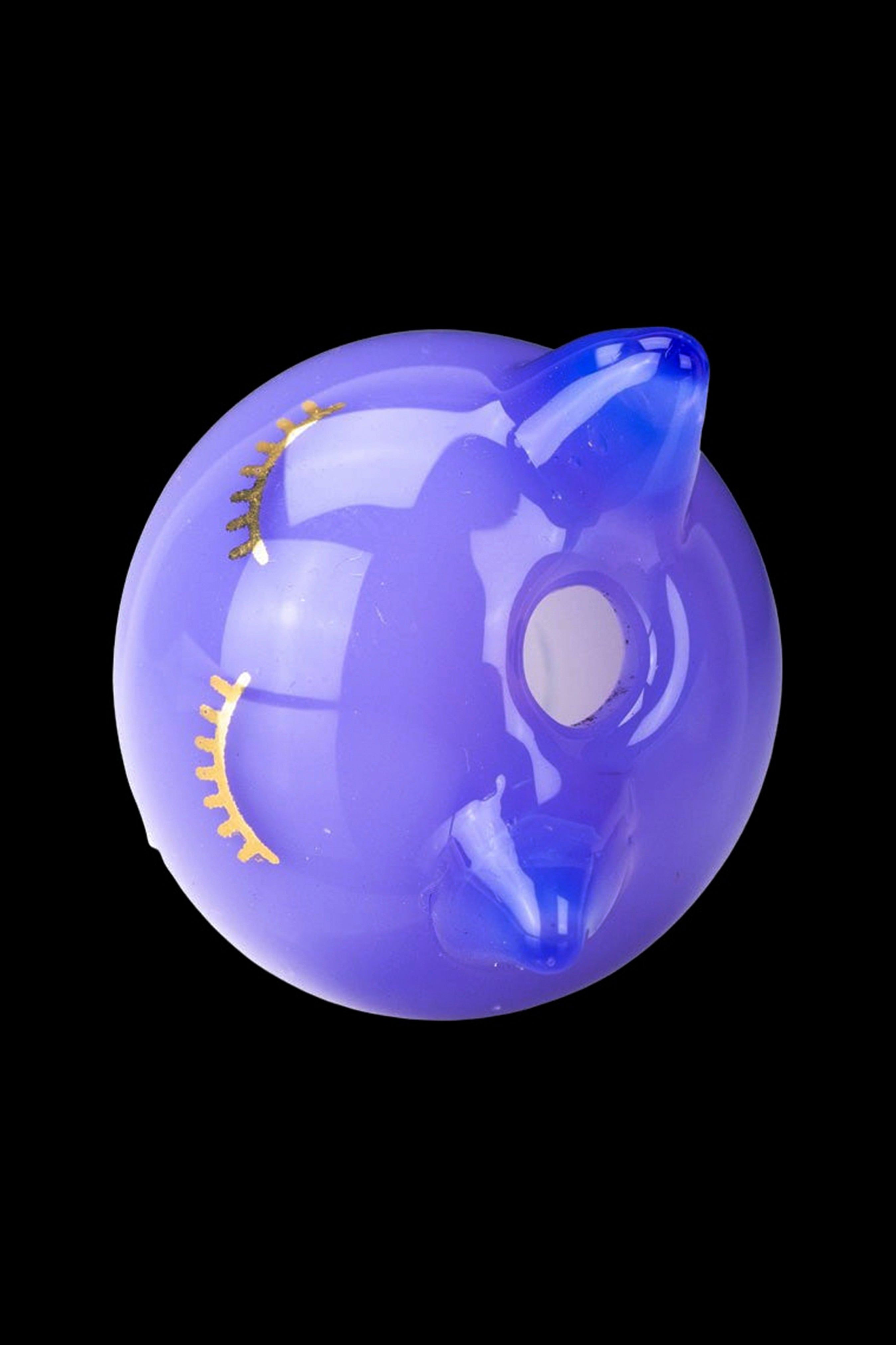 Purple glass water pipe resembling a unicorn head, isolated on a black background.