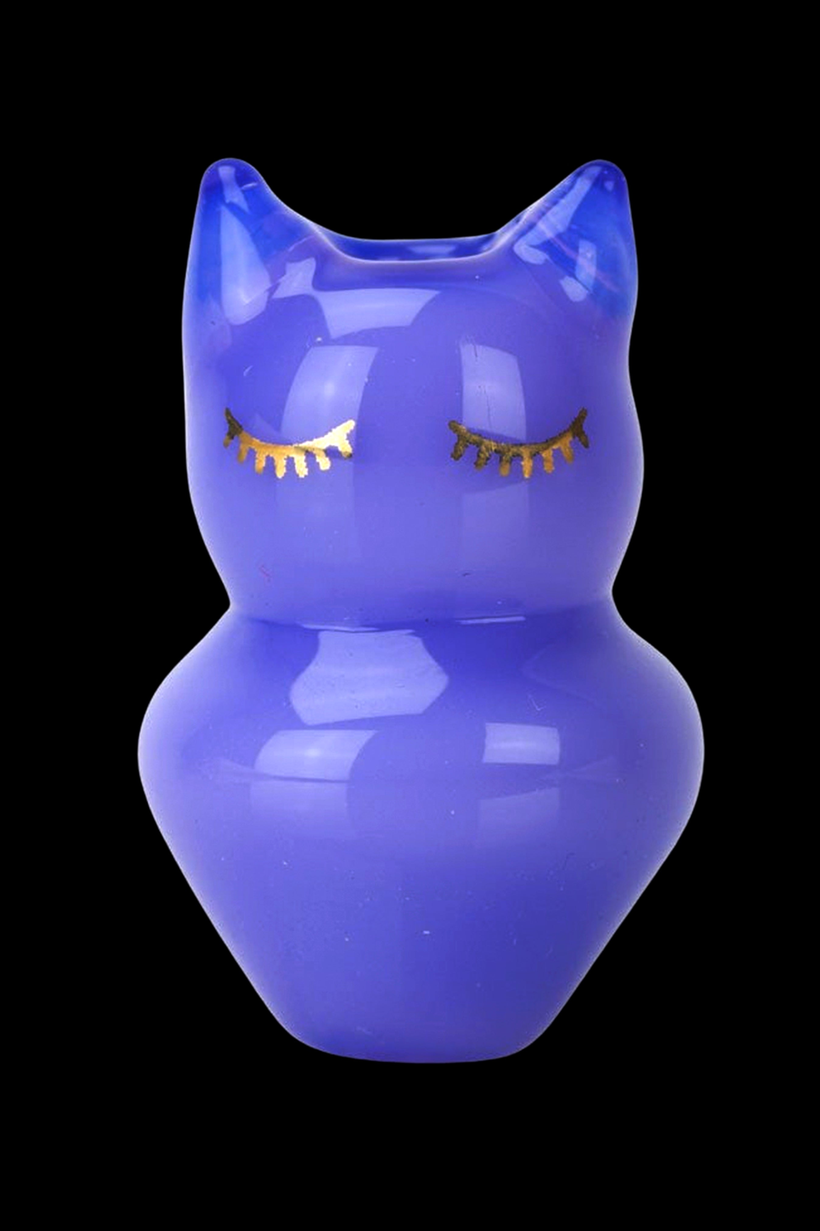 Blue glass water pipe shaped like a female figure with gold-colored eyelashes, isolated on a black background.