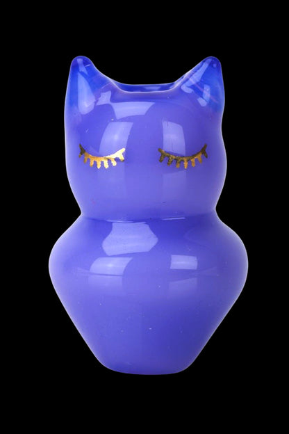 Blue glass water pipe shaped like a female figure with gold-colored eyelashes, isolated on a black background.