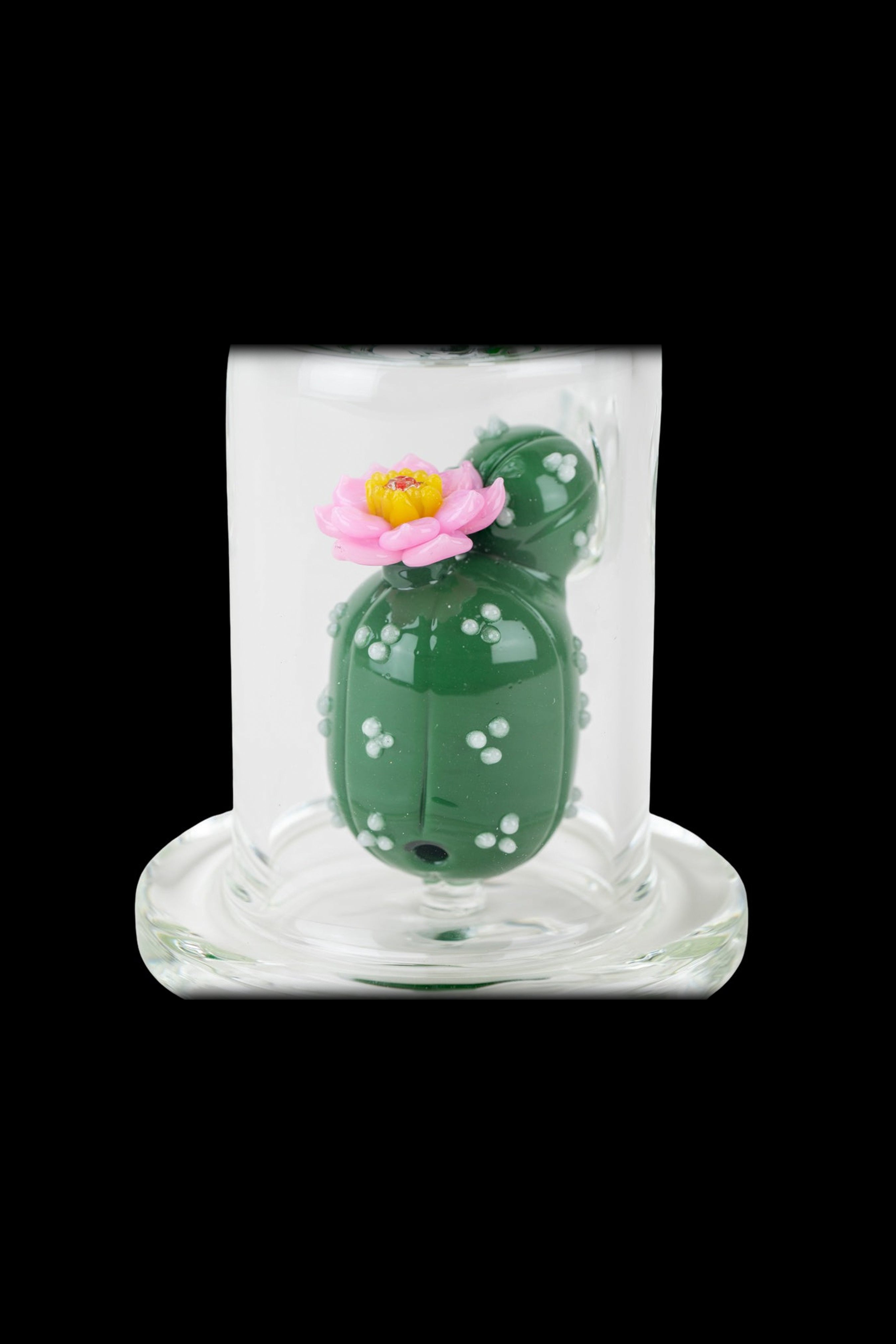 Green cactus-shaped glass water pipe with a pink flower, encased in clear glass.