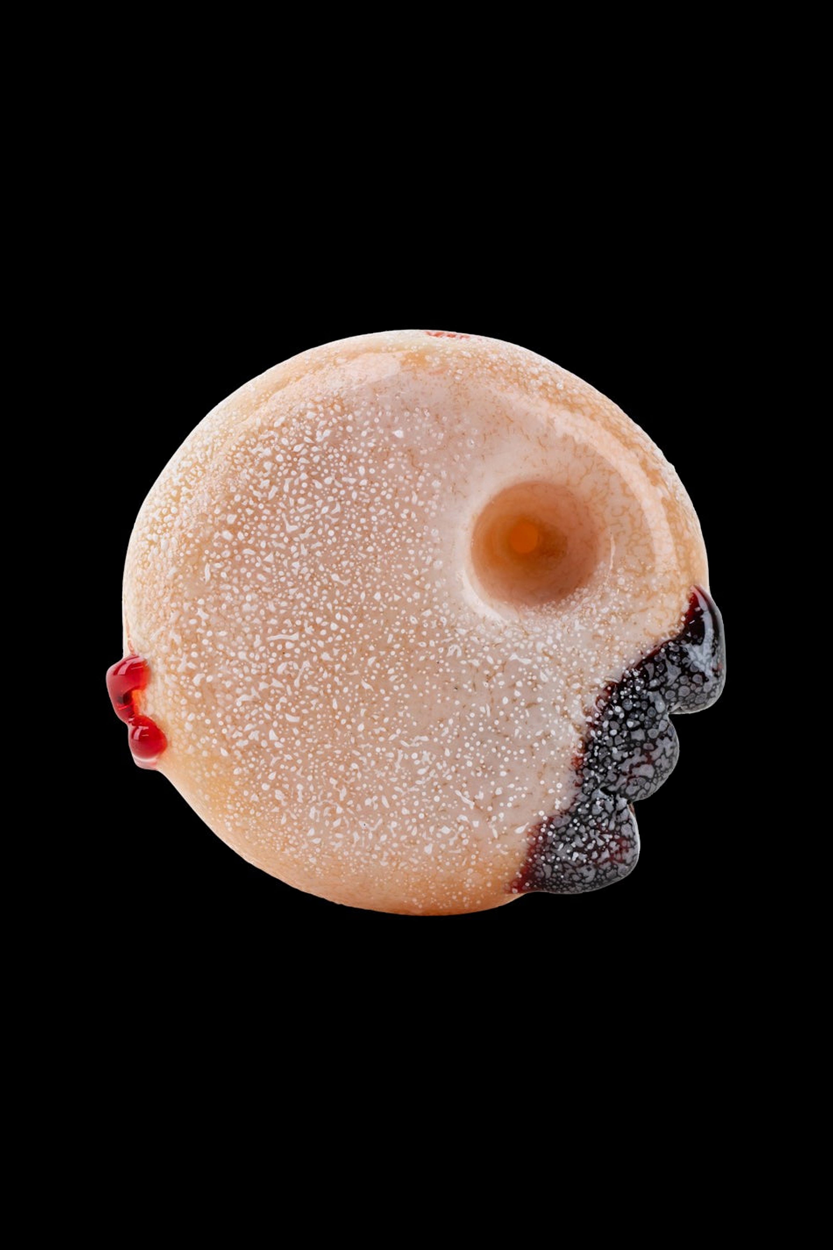 Glass pipe shaped like a powdered donut with black berry-like accents.