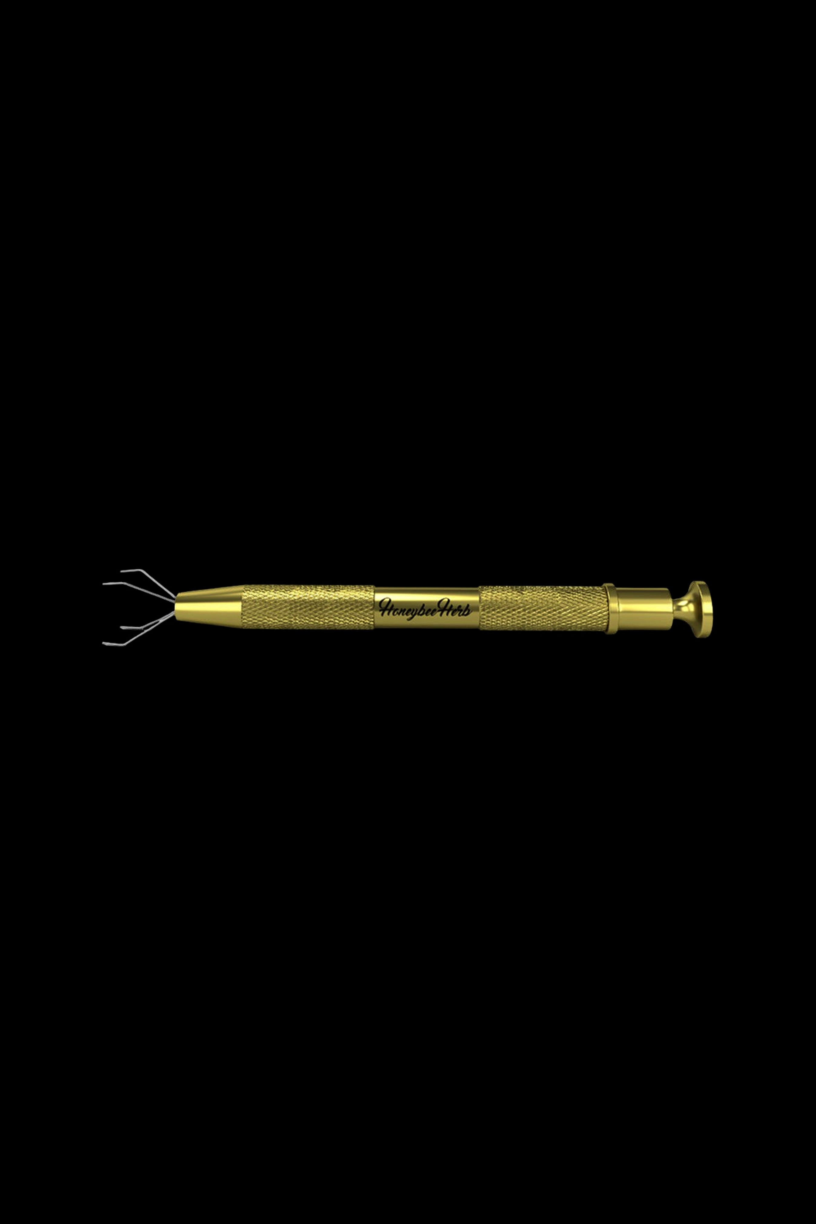 Gold cannabis dab tool with four prongs and textured grip.